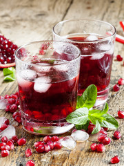 Fresh red juice cocktail with pomegranate seeds, mint and ice, s