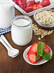 Yogurt in a glass jars with strawberry and oatmeal. 