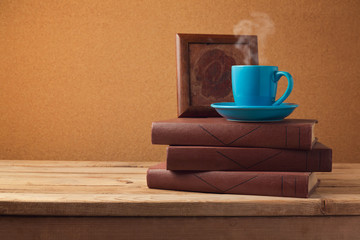 Coffee cup and books on wooden vintage table