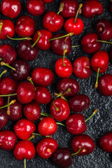 Fresh ripe organic cherries on black background
