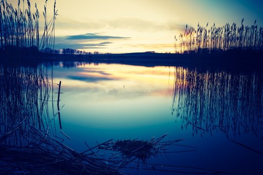 Vintage photo of beautiful sunset over calm lake
