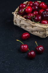 Fresh ripe organic cherries on black border  background