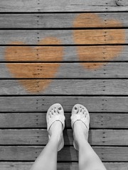 feet and heart on wood floor. 