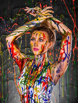 Beautiful young woman covered with paints