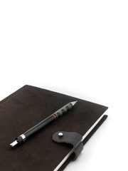 Brown notebook and pencil on white background