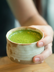  Matcha Green Tea in woman hand.