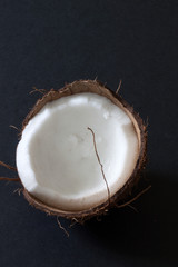 Half a coconut displayed on a dark background