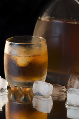 Glass with whiskey and a full whiskey bottle