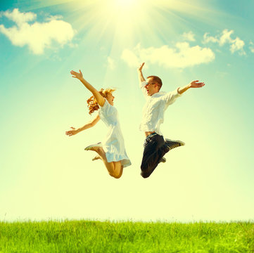 Happy Couple Outdoor. Jumping Family On Green Field