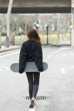 Hipster girl walks on road in the street, adolescence lifestyle.