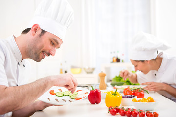 Young attractive professional chef cooking in his kitchen