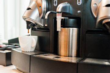 Coffee machine pouring into white cup