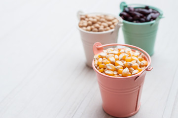 Bulk of corn grain on wooden table, macrobiotic food or healthy