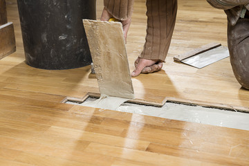 Carpenter Applying Parquet Glue
