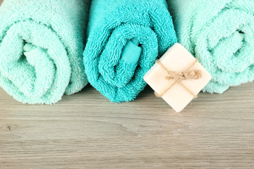 Obraz na płótnie Canvas Beautiful towels with soap on wooden background