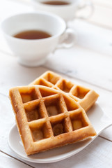 waffles and tea on white wooden board