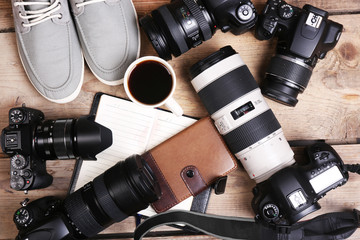 Still life with modern cameras on wooden table, top view