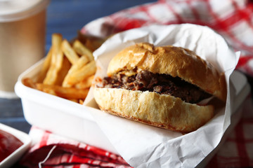 Tasty burger and french fries on wooden table background  Unhealthy food concept