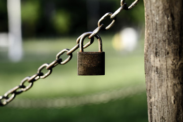 Closeup photo of brown padlock hanging on chains