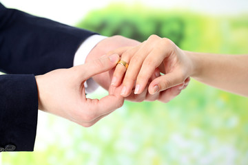 Obraz premium Woman and man holding wedding rings, close-up, on bright background
