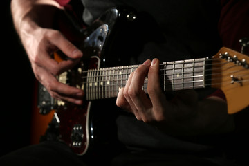 Plakat Young man playing on electric guitar close up