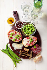 Italian snacks. salami sandwich with parmesan cheese & broad bea