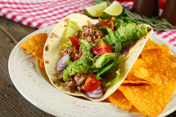 Mexican food Taco in plate on wooden table, closeup