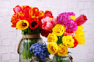 Beautiful flowers in vases on wall background