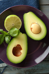 Sliced avocado and lemon lime on wooden background