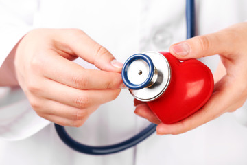 Doctor hands with stethoscope and red heart, closeup