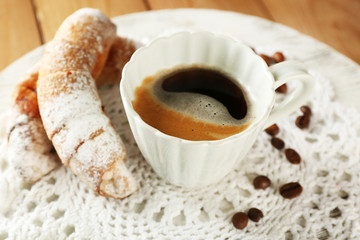 Cup of coffee with cookie on table, closeup