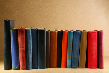 Old books on shelf, close-up, on wooden background