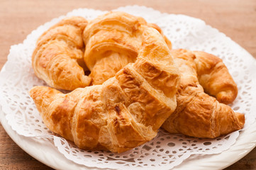 fresh croissants on wooden table