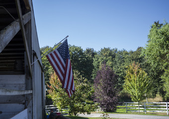 American flag hanging from a horse stable.