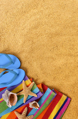 Summer beach sand background border with couple sunbathing towel star fish and accessories photo space for copy text vertical