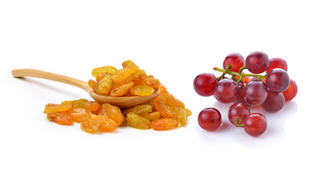 Dried raisins in the wood spoon and grapes on a white background