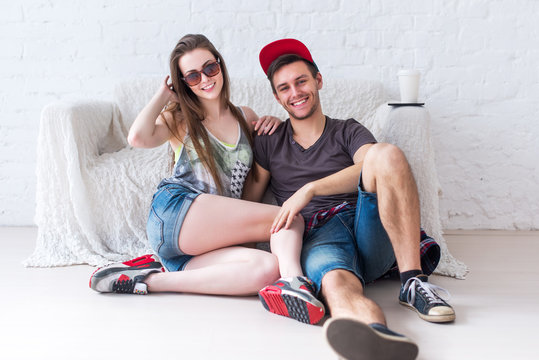 Friends girl and guy sitting on floor at home in summer