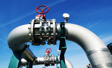 Industrial zone, Steel pipelines and valves against blue sky