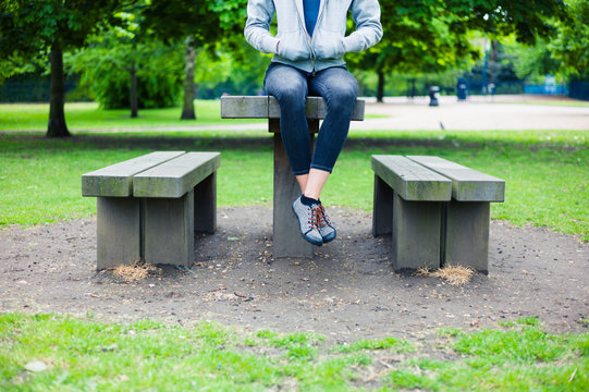 Woman sitting on table in park