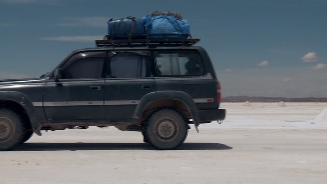 SUV on salt flat Salar de Uyuni in Andes of Bolivia
