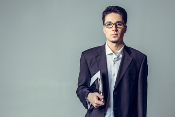 Young businessman holding clipboard with blank sheet of paper
