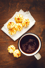 Big Cup of Tea with Tiny Cookies on Wooden Table