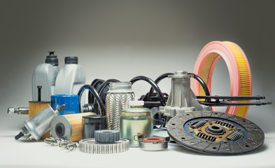 Car engine parts and motor oil on grey background