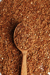 Buckwheat in a spoon on brown wooden background