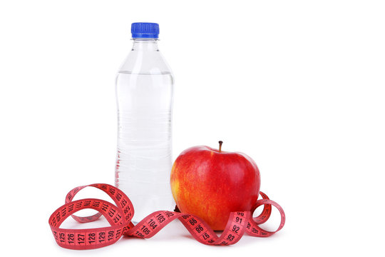 Red apple with measuring tape and bottle isolated on white