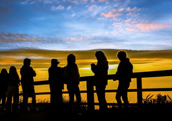 Fototapeta na wymiar Silhouettes tourists are looking sunrise at view point