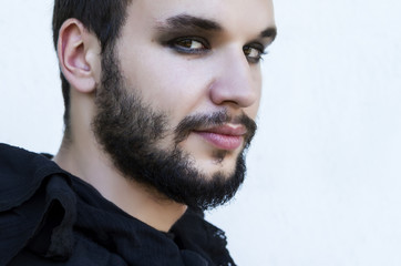 Fototapeta premium Portrait of a male model with Smokey eyes and black clothes