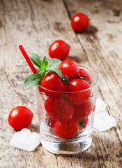 Funny cool tomato juice and tomatoes in a glass, selective focus