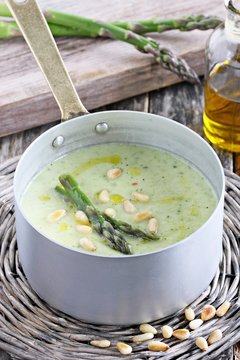 Asparagus cream soup with pine nuts and asparagus topping
