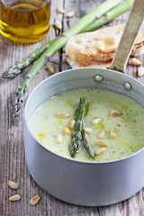 Asparagus cream soup with pine nuts and asparagus topping
